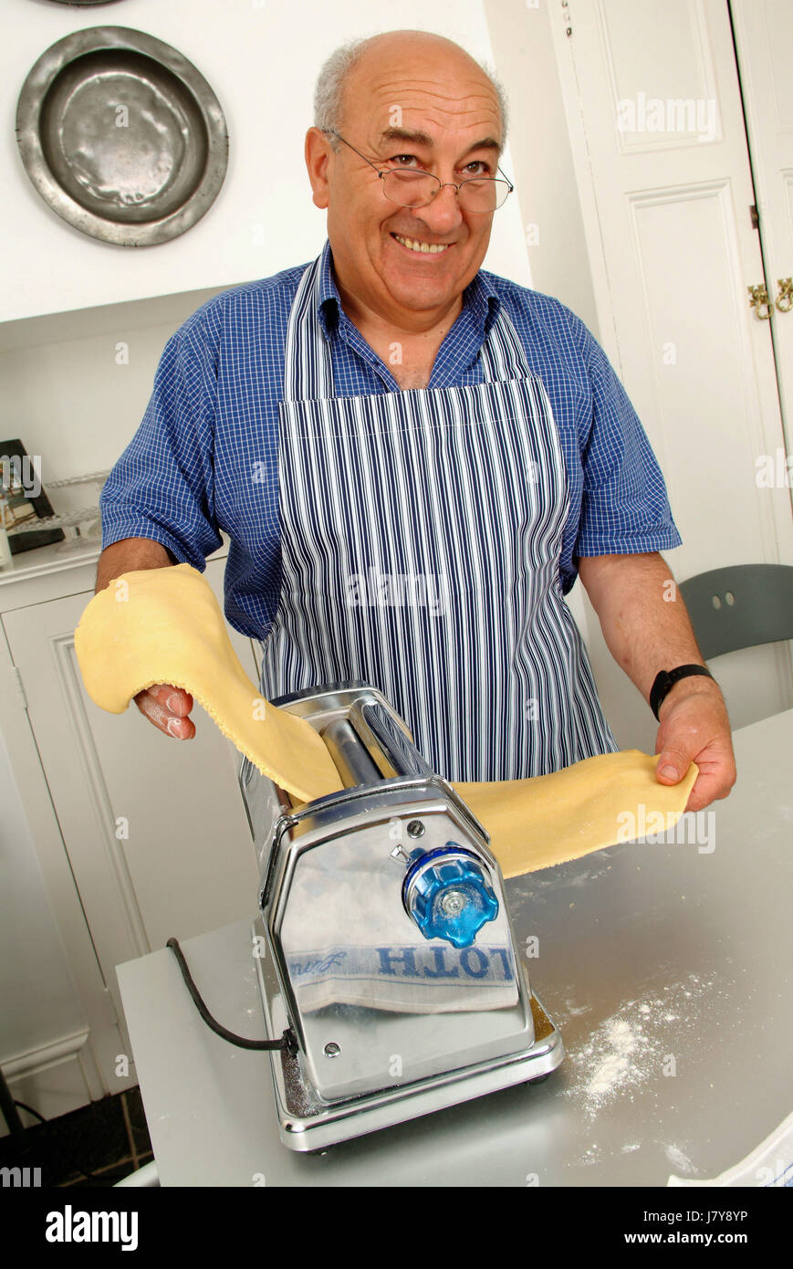 El chef italiano Franco Taruschio hacer hojas de pasta en la cocina de su casa, usando una pasta maker. Foto de stock