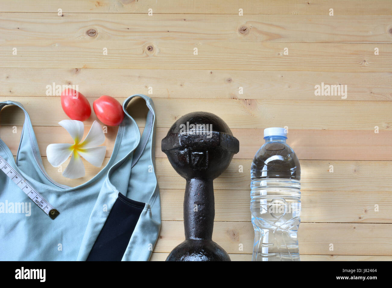 Equipo de ejercicio de zapatillas de deporte blanco, manzana, cinta métrica, botella de plástico y old rusty pesa para el ejercicio y la salud con mesa de madera vista superior Foto de stock