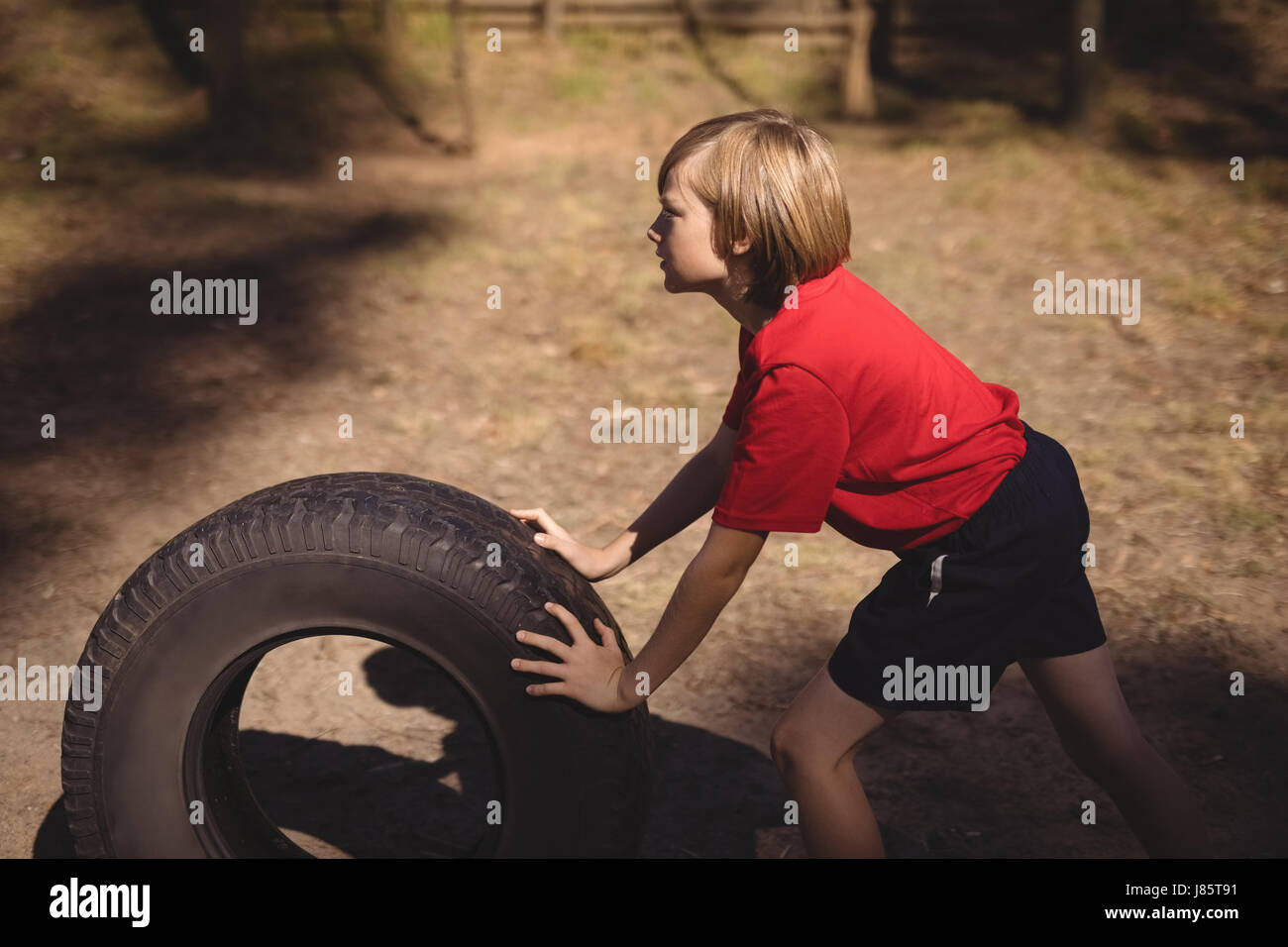 Determina chica ejerciendo con enorme neumático durante carrera de  obstáculos en boot camp Fotografía de stock - Alamy