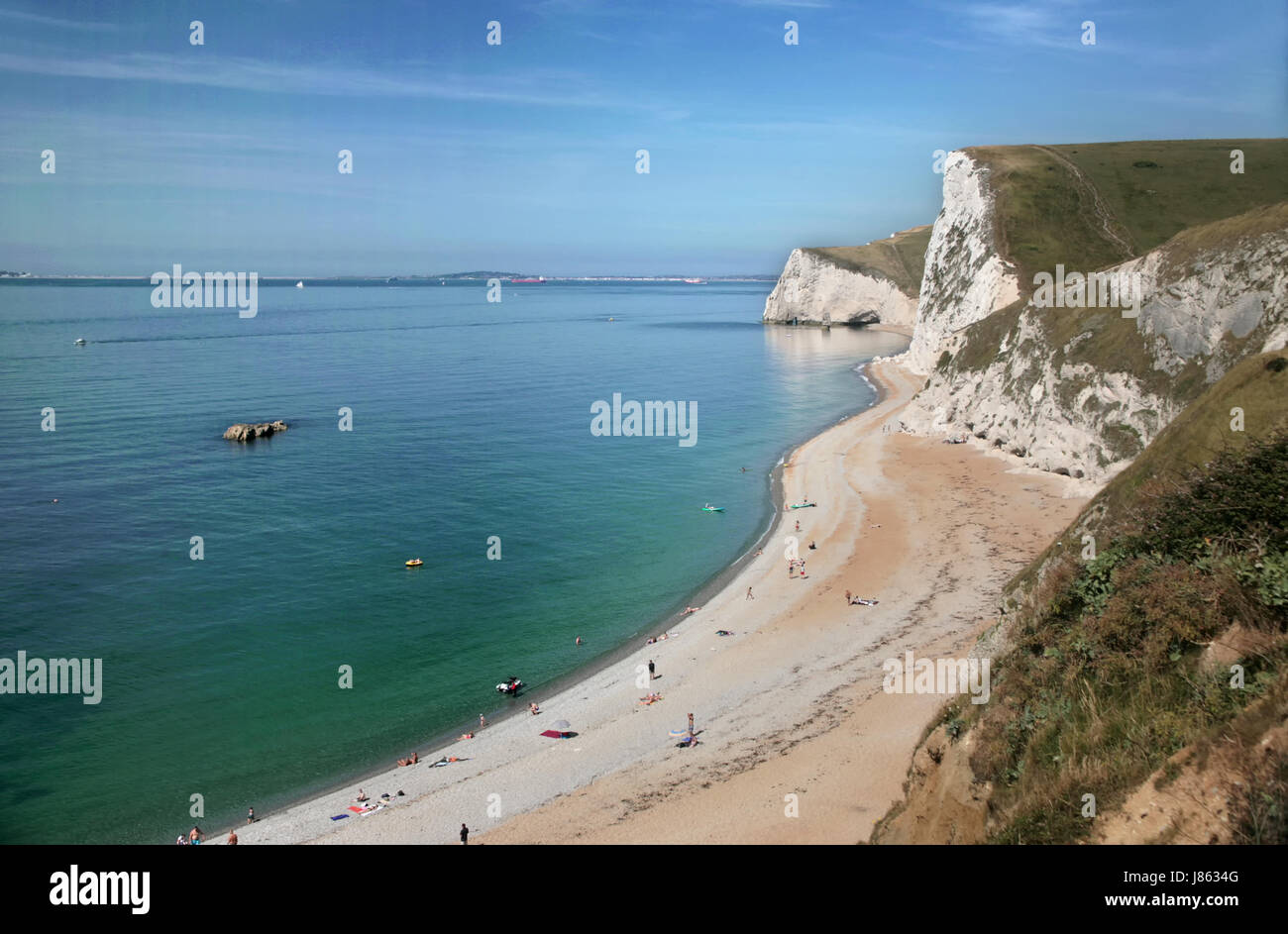 La vista al oeste a lo largo de la Costa Jurásica, en Dorset, puerta de Durdle Swyre con cabeza en el fondo y el Toro rock justo al mar Foto de stock