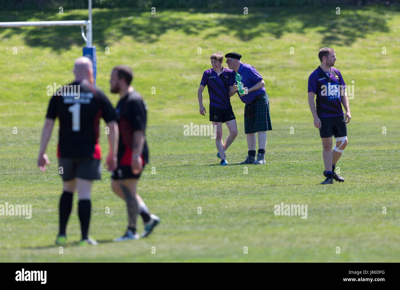 Hombre en falda habla al jugador de rugby durante el match Foto de stock