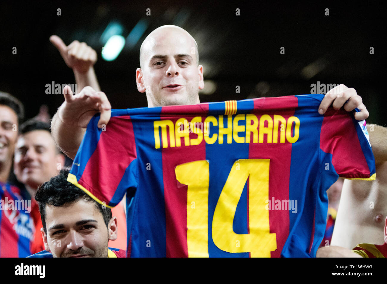 Madrid, España. 27 de mayo de 2017. Un seguidor del FC Barcelona celebra el  segundo gol de su equipo con una camiseta de Mascherano durante el partido  de fútbol de la Final