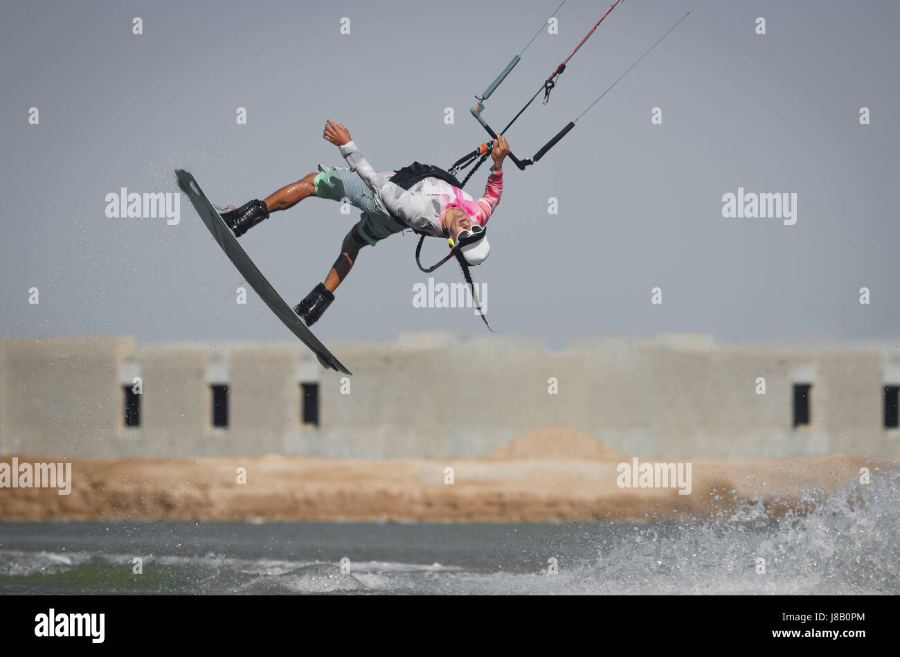 Kite Surf Rider deportista profesional salta alta acrobacia kiteboarding rabieta truco con rotación frontal y agua splash. Recreación Foto de stock