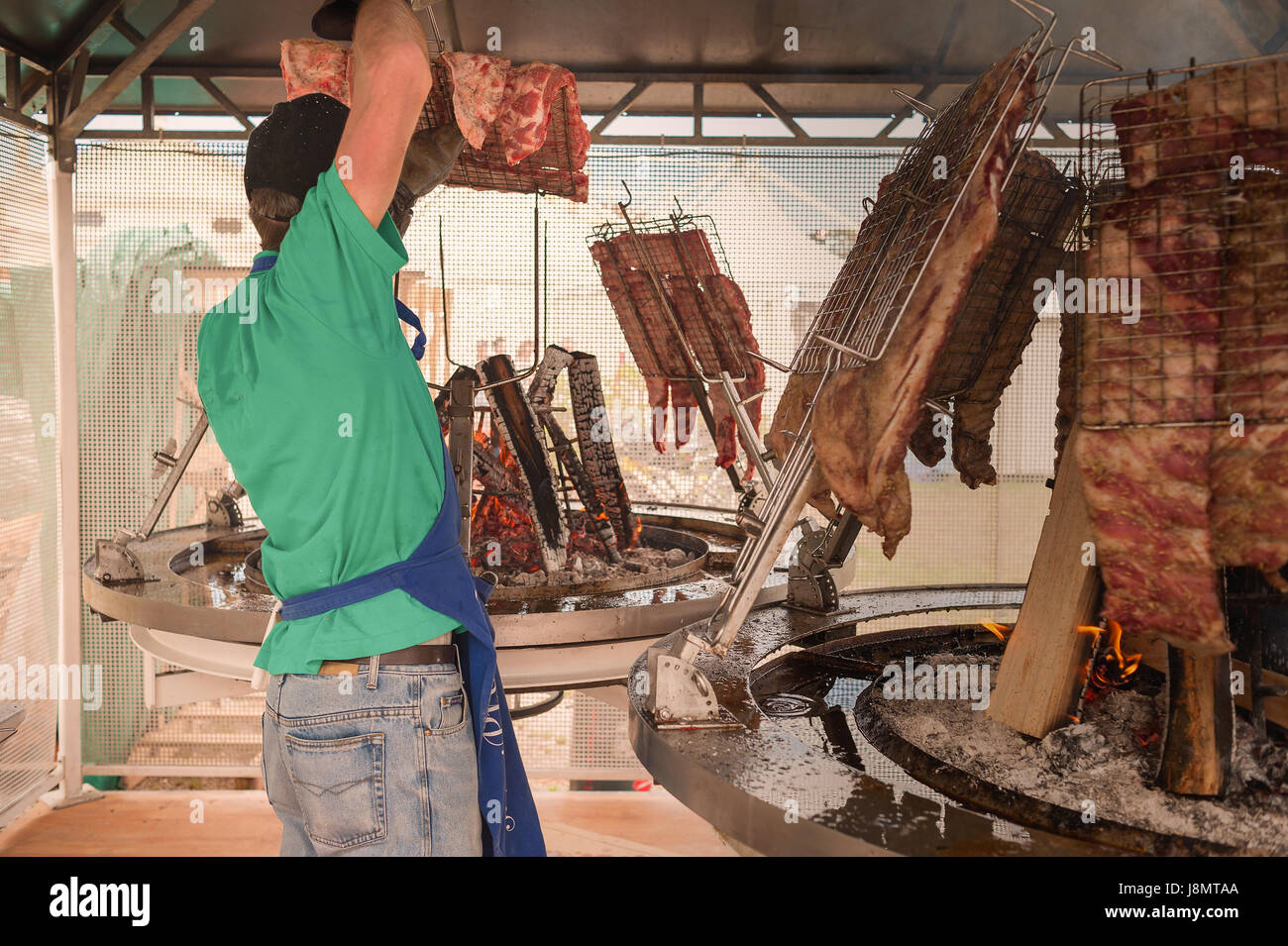Cocinero prepara la carne para asar a la parrilla. Asado Argentino. Foto de stock