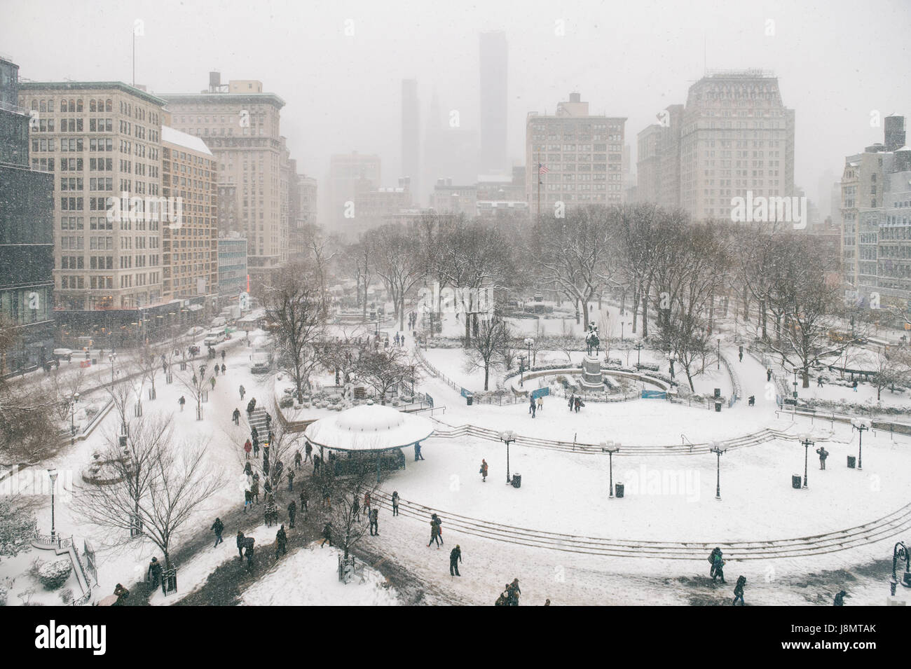 Escena de invierno con nieve con senderos dejados por los peatones en la nieve en Union Square como blizzard adelanta a la ciudad de Nueva York Foto de stock