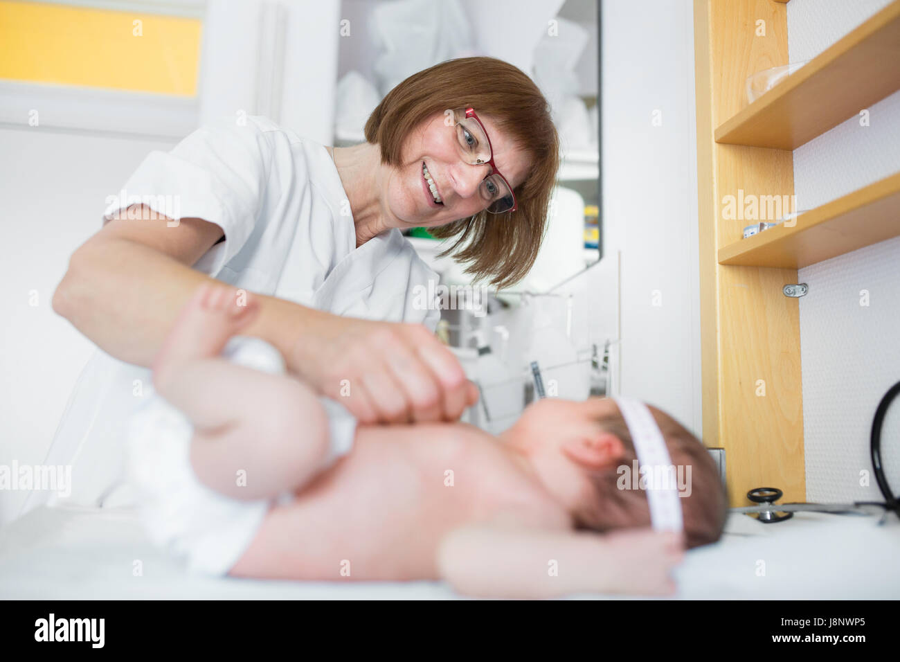 Bebé (0-1 meses) que está siendo examinado por la enfermera Foto de stock