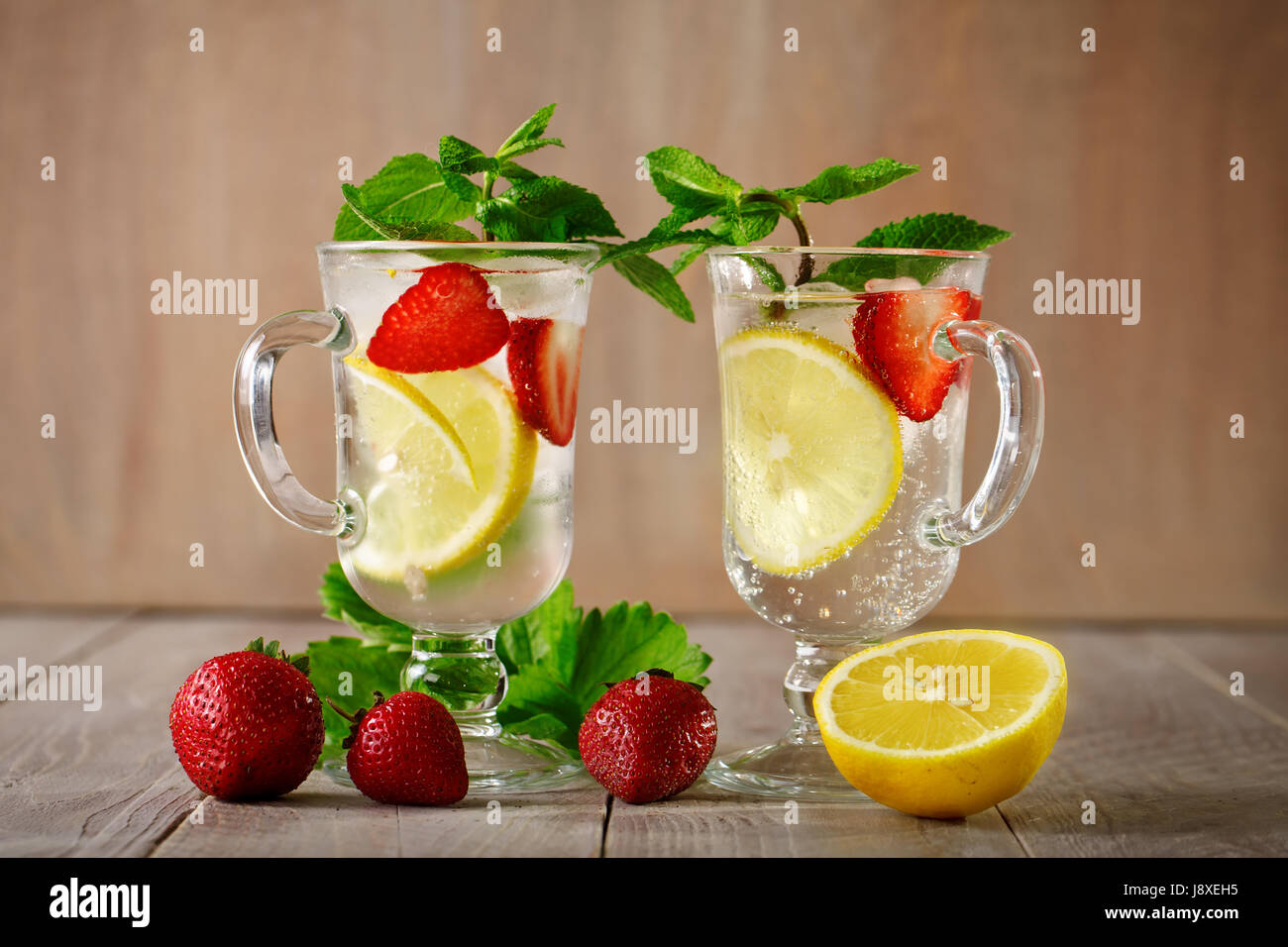 Verano fresco saludable bebida con limón y fresas con hielo. Foto de stock