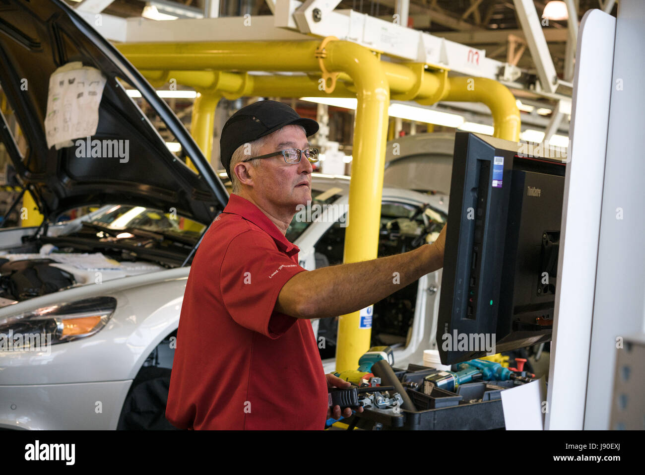 Gaydon, REINO UNIDO - 08/10/2016. Un trabajador comprueba las notas en la línea de montaje. Foto de stock