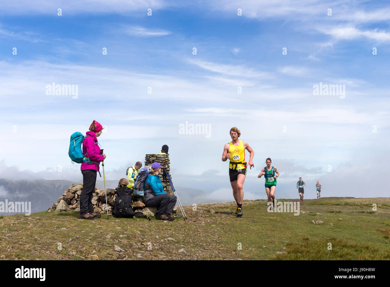 Los paseantes sobre la Cumbre de Clough Jefe viendo los corredores que toman parte en el Helvellyn y Dodds cayó la raza, Lake District, Cumbria, Reino Unido. Foto de stock