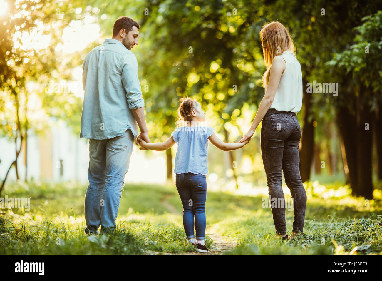 En El Parque De La Familia Mama Papa Y Bebe Feliz Paseo Al Atardecer El Concepto De Una Familia Feliz Los Padres Tienen Las Manos Del Bebe Fotografia De Stock Alamy