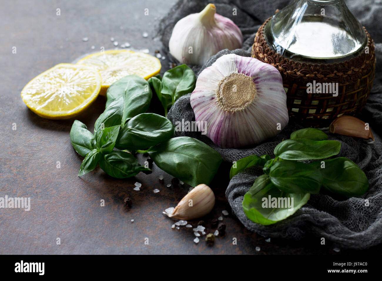 Ingredientes para cocinar - ajo, limón, albahaca, especias y aceite de oliva. Fondo de alimentos en la mesa de la cocina. Vista desde arriba. Copie el espacio. Foto de stock