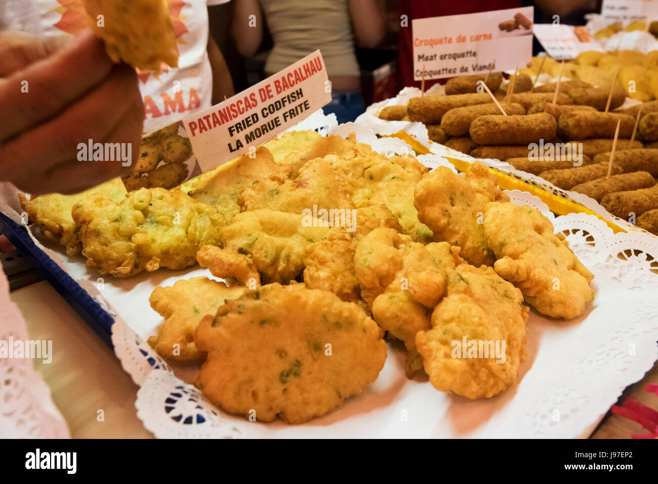 Pataniscas de bacalhau (bacalao frito), un manjar, en la popular fiesta de Santo Antonio, en el distrito de Alfama. Lisboa, Portugal Foto de stock