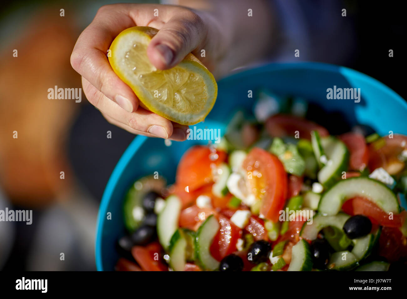 Tradicional comida de picnic, con una ensalada griega con jugo de limón siendo cuadrados en él bowl Foto de stock