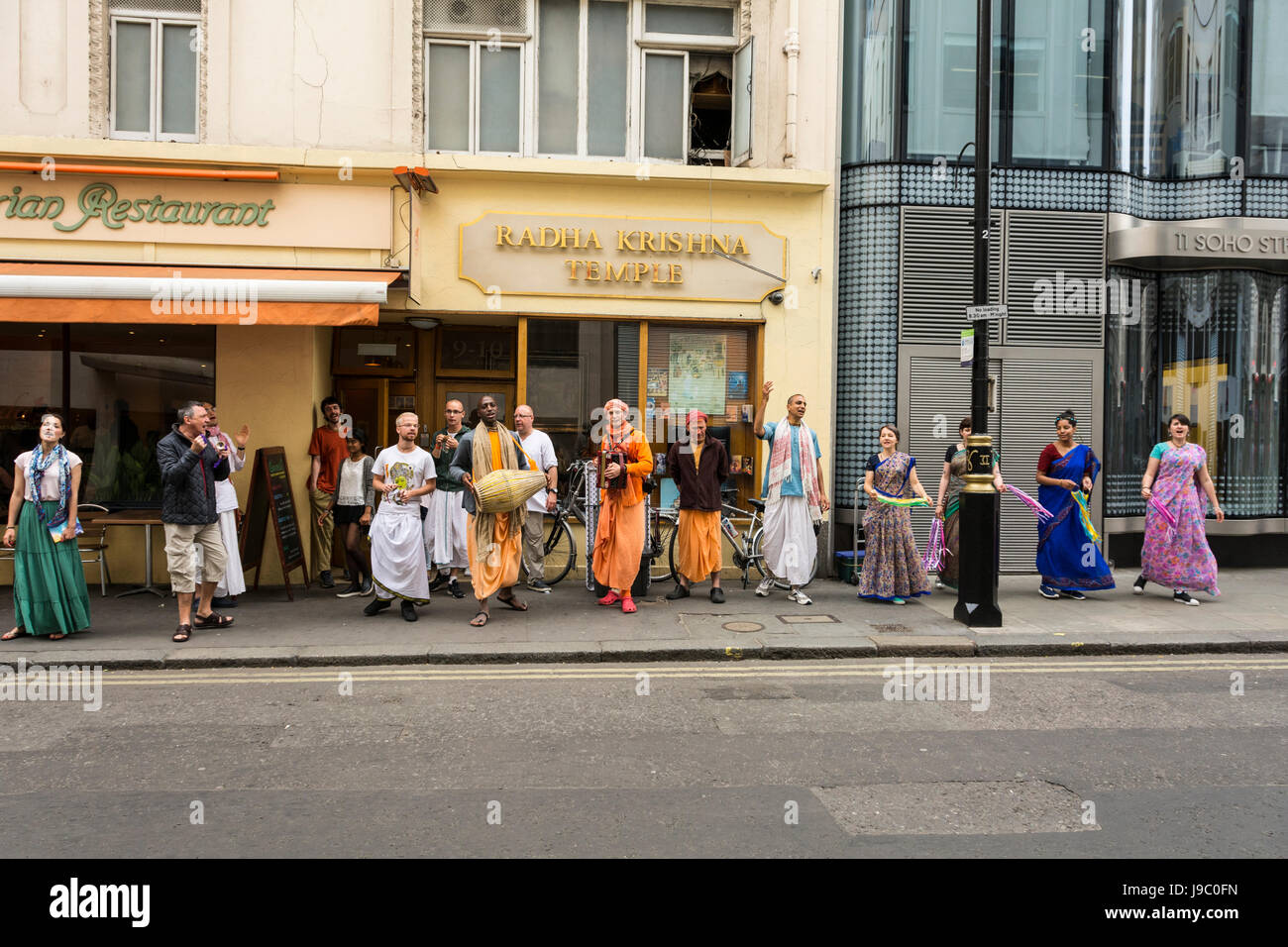 Los devotos bailando y cantando fuera del templo de Radha-Krishna en Soho Street, London, UK Foto de stock