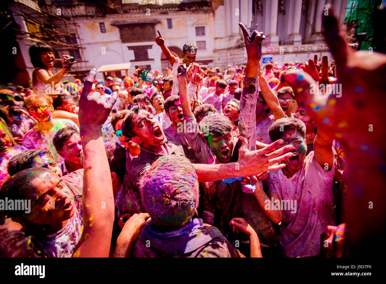 Multitud arrojando pigmento en el festival de Holi, la Plaza Durbar, Katmandú, Nepal, Asia Foto de stock