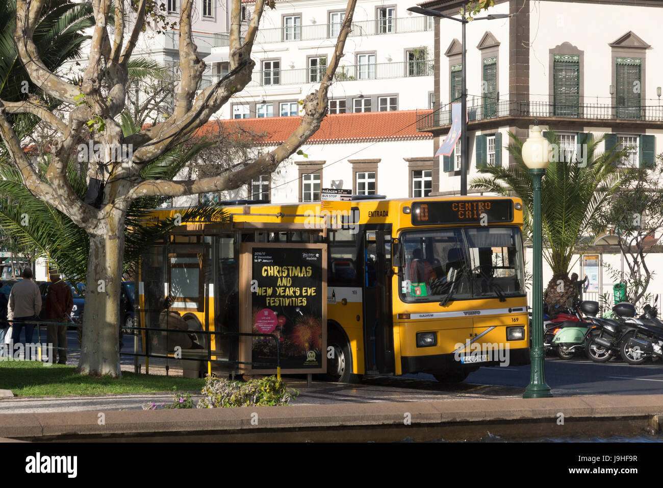 Un autobús en una parada de autobús, publicidad de navidad y fiestas de Nochevieja en Funchal, Madeira Foto de stock