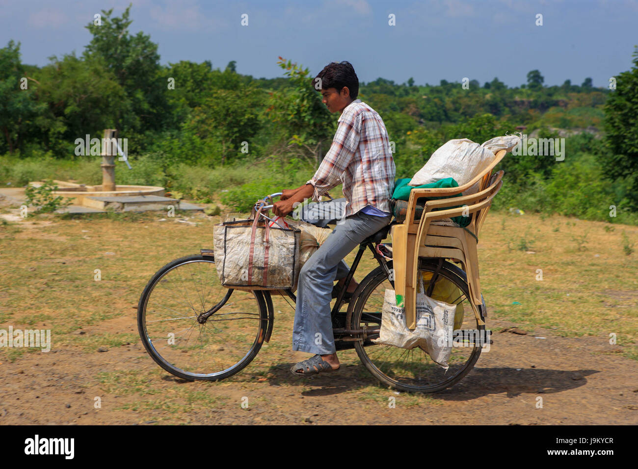 Boy montando bicicleta con hogar de equipaje, Madhya Pradesh, India, Asia Foto de stock