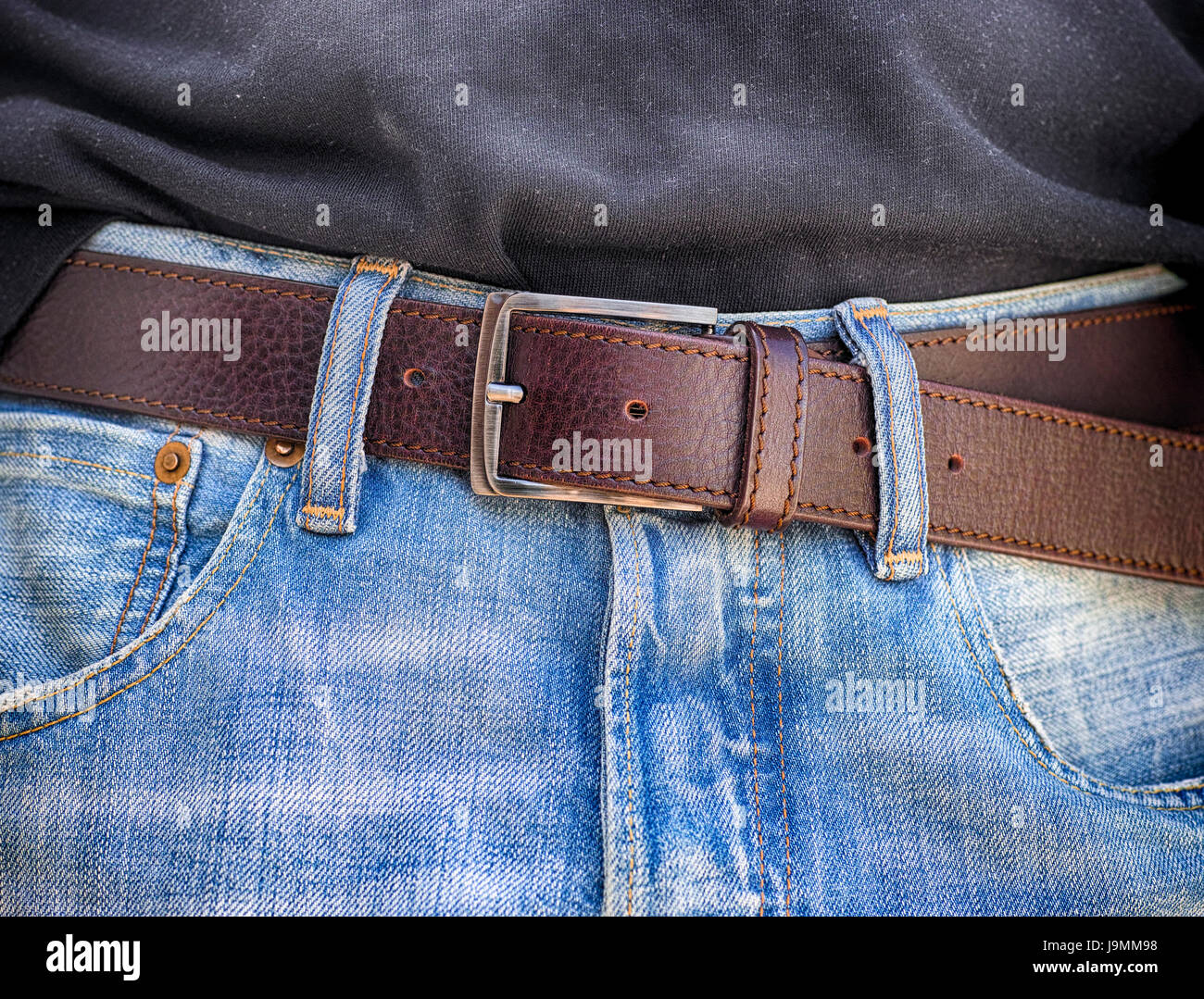 Blue jeans con correas de cuero. Cerca. Foto de stock