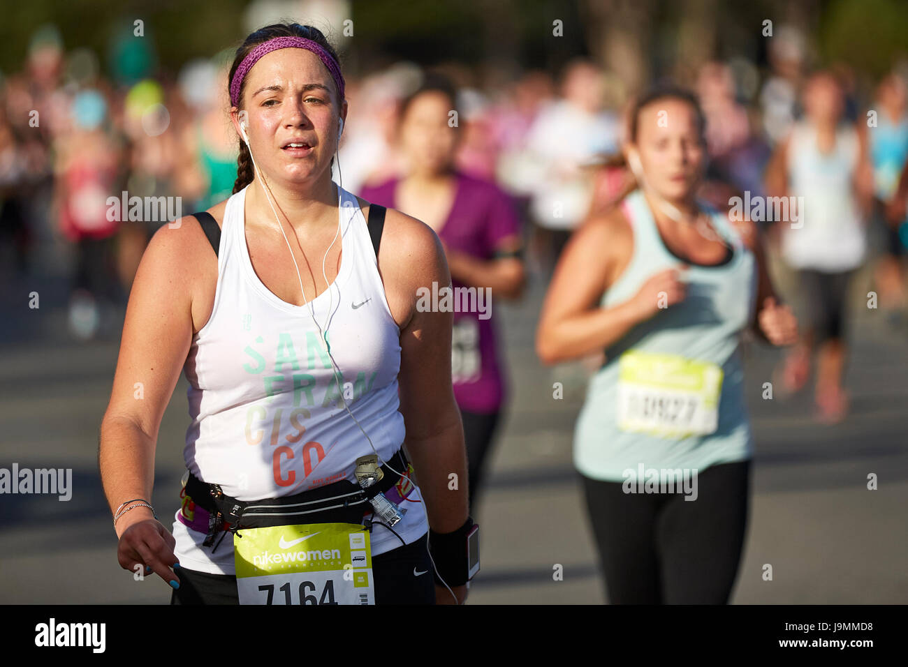 Agotada la atleta femenina acercándose a la línea de meta en la media maratón de la mujer Nike, San Francisco. Foto de stock