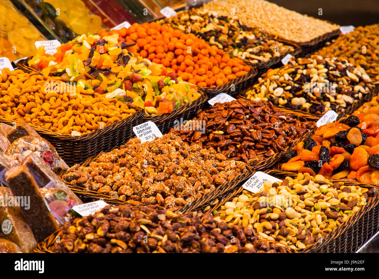 Apetitoso muestra de frutas, vegetales, nueces, dulces, carnes, pescados y quesos saludar a los visitantes a la expansión del mercado de La Boquería en Barcelona, España. Foto de stock