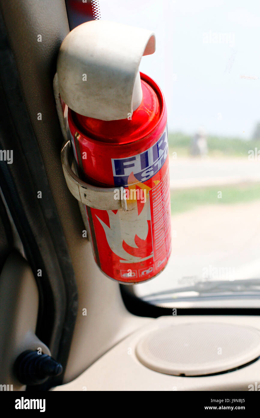 Un extintor de incendios para fines de emergencia delante del asiento de coche Foto de stock