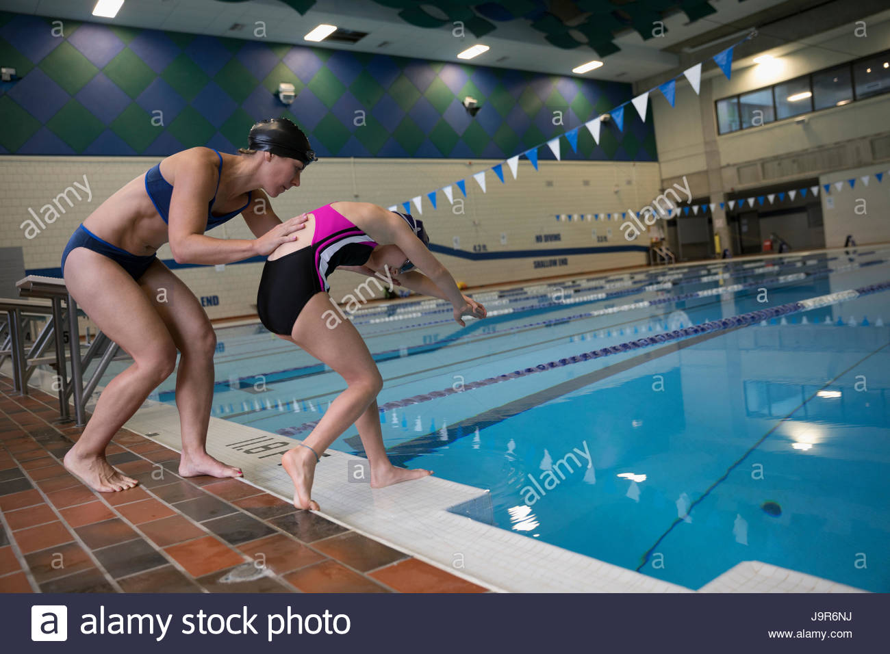 Madre Hija de coaching nadador de buceo en piscina Foto de stock