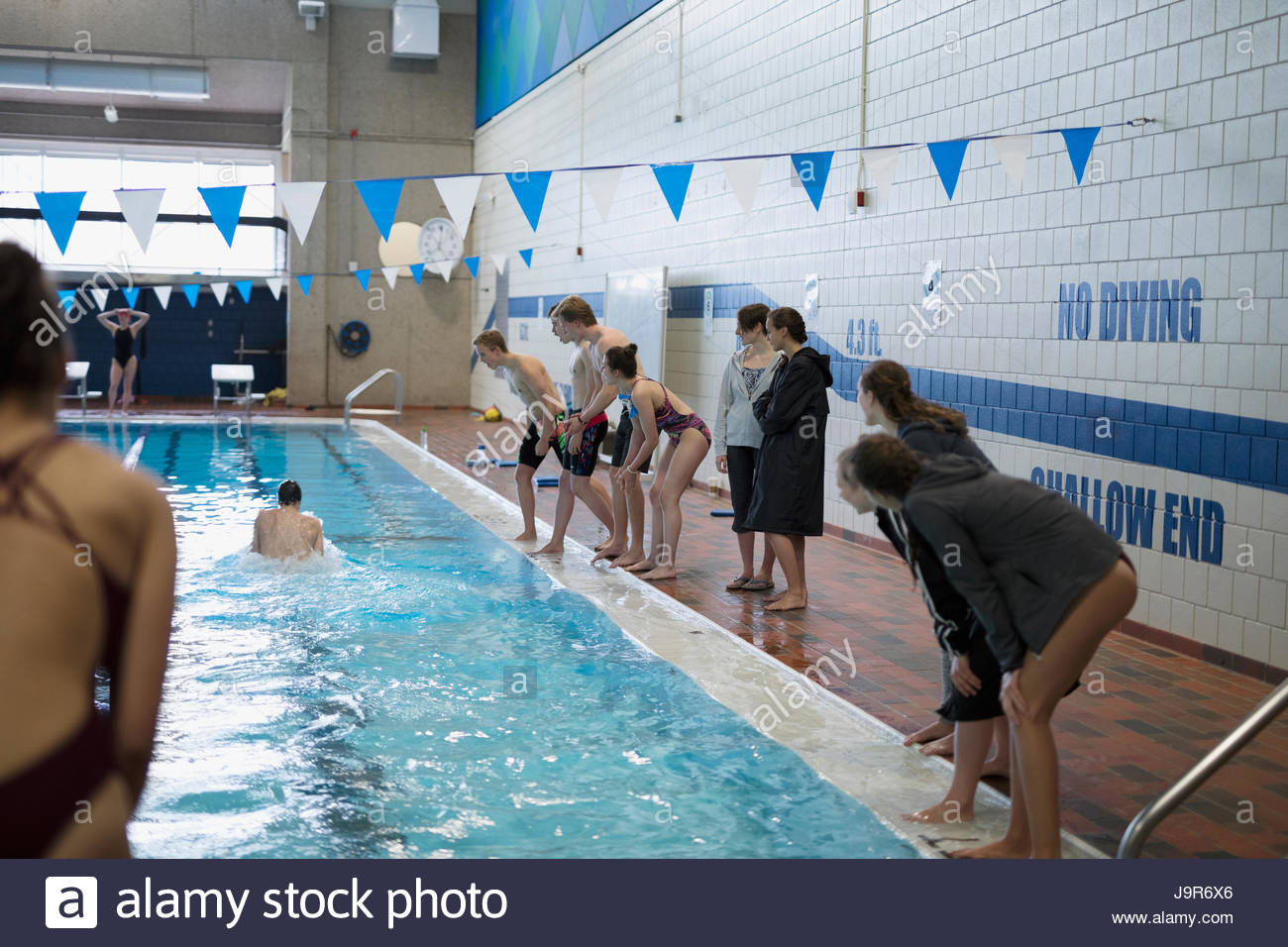 Equipo de Natación vítores teammate nadando en la piscina en el atletismo competitivo Foto de stock