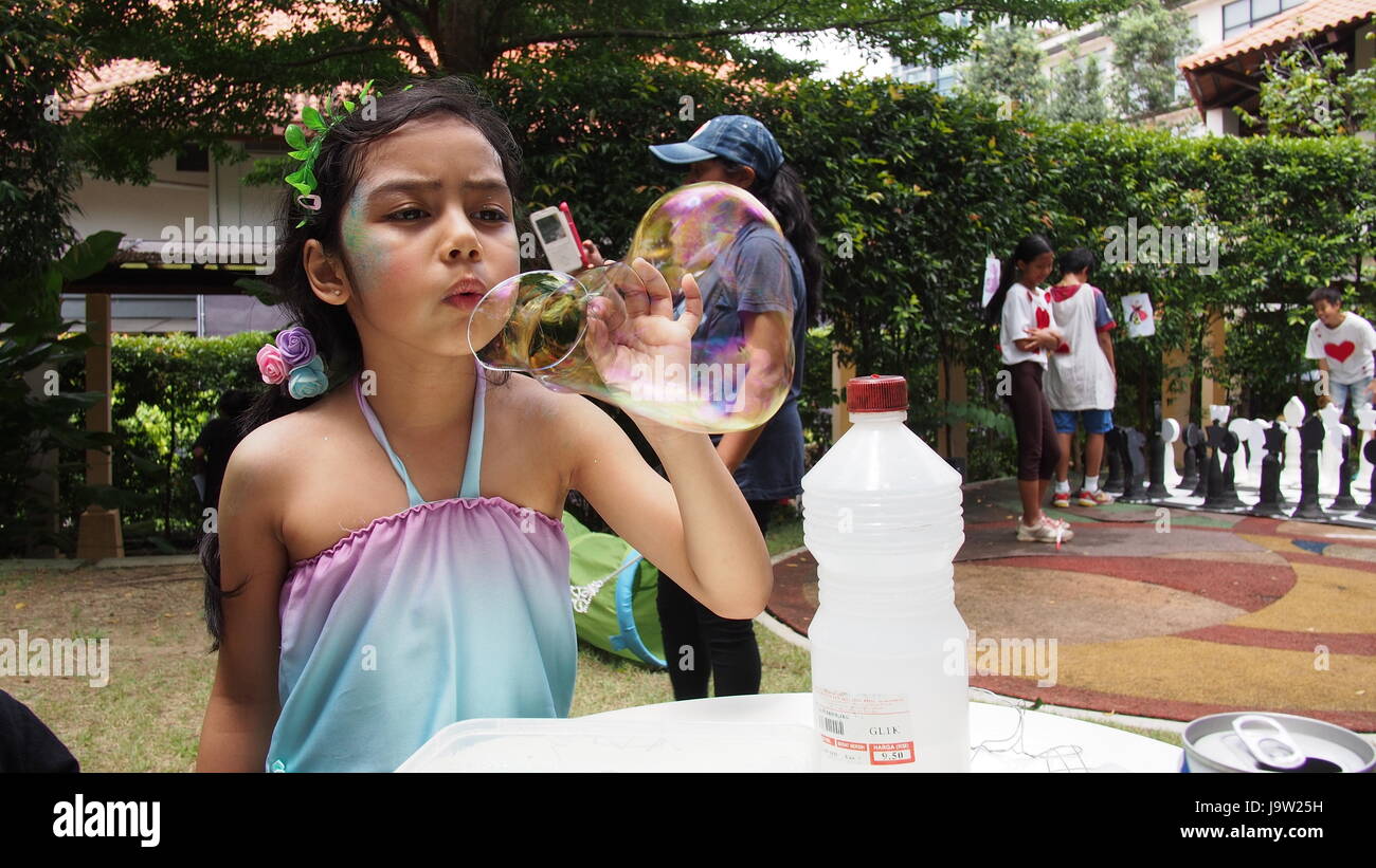 Niño soplando burbujas en una fiesta de niños Foto de stock