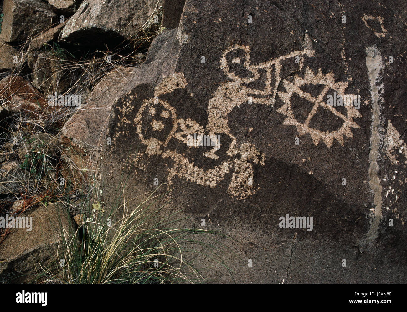 (Kokopelli fluteplayer), símbolo del sol, máscara y otras tallas de Pueblo Comanche brecha volcánica Galisteo Dyke, Cuenca, Nuevo México, EE.UU.: Rio Grande estilo. Foto de stock