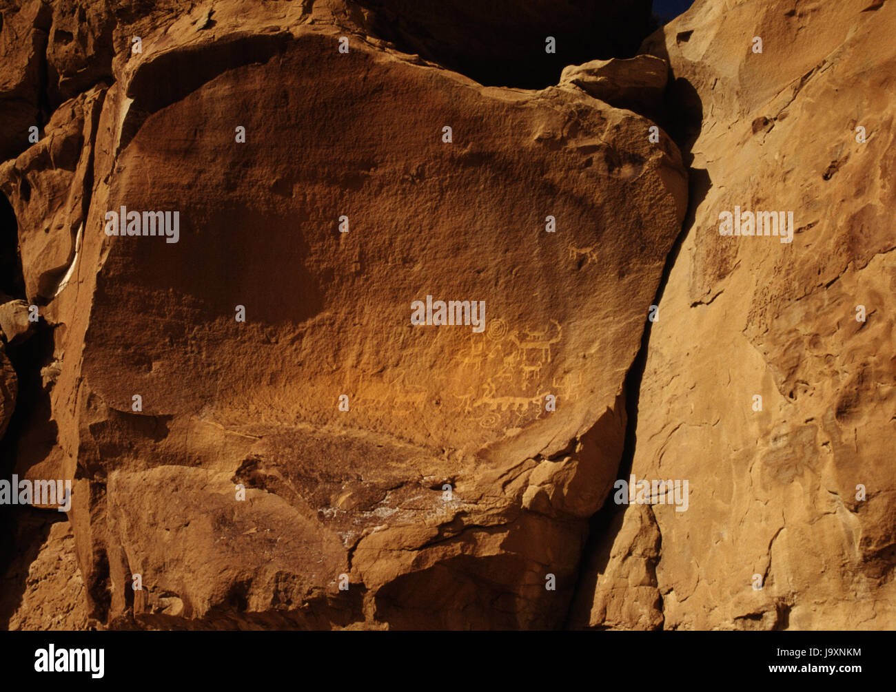 San Juan Anasazi tallados en la pared del cañón de piedra arenisca en una vida de pueblo, Cañón del Chaco, Nuevo México, EE.UU.: anthropomorph con espiral & horned cuadrúpedos. Foto de stock