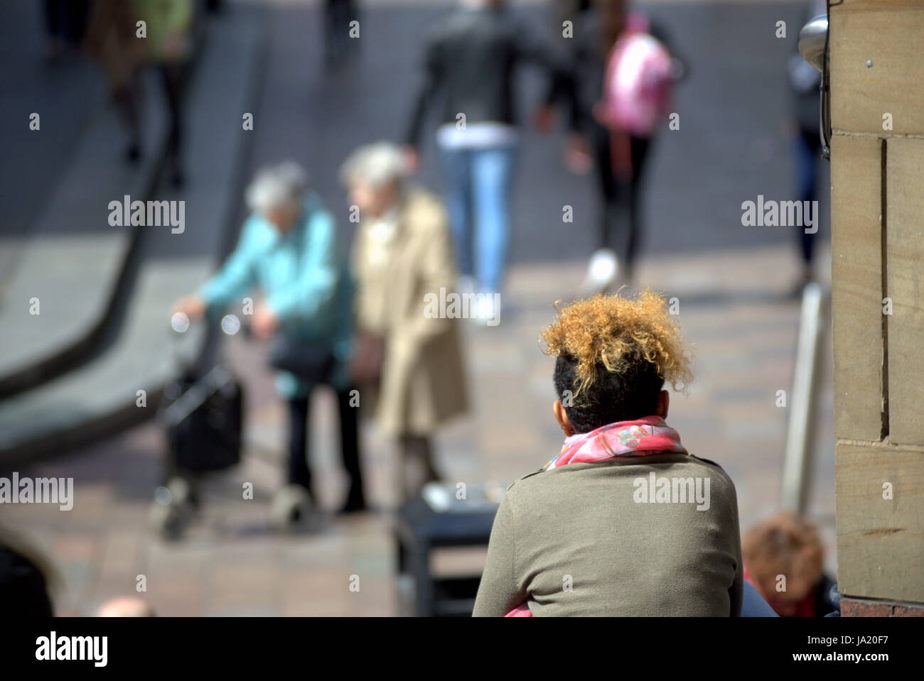 Los jóvenes contemplando la edad joven mirando a ciudadanos de la tercera edad con zimmer frame Foto de stock