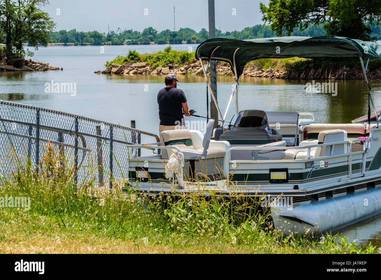 Un hombre caucásico en su 40s peces desde un Pontoon Boat en el río del norte de Canadá, cerca de la ciudad de Oklahoma, Oklahoma, Estados Unidos. Foto de stock