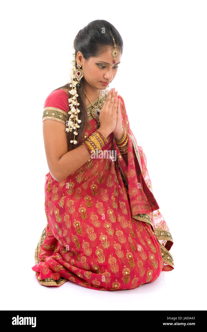 Niña india en una de saludo, sari tradicional traje, longitud total de rodillas en suelo aislado sobre fondo blanco Fotografía de - Alamy