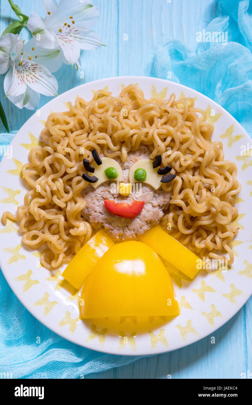 Funny Girl comida cara con Chuleta, Pasta de fideos y verduras Foto de stock