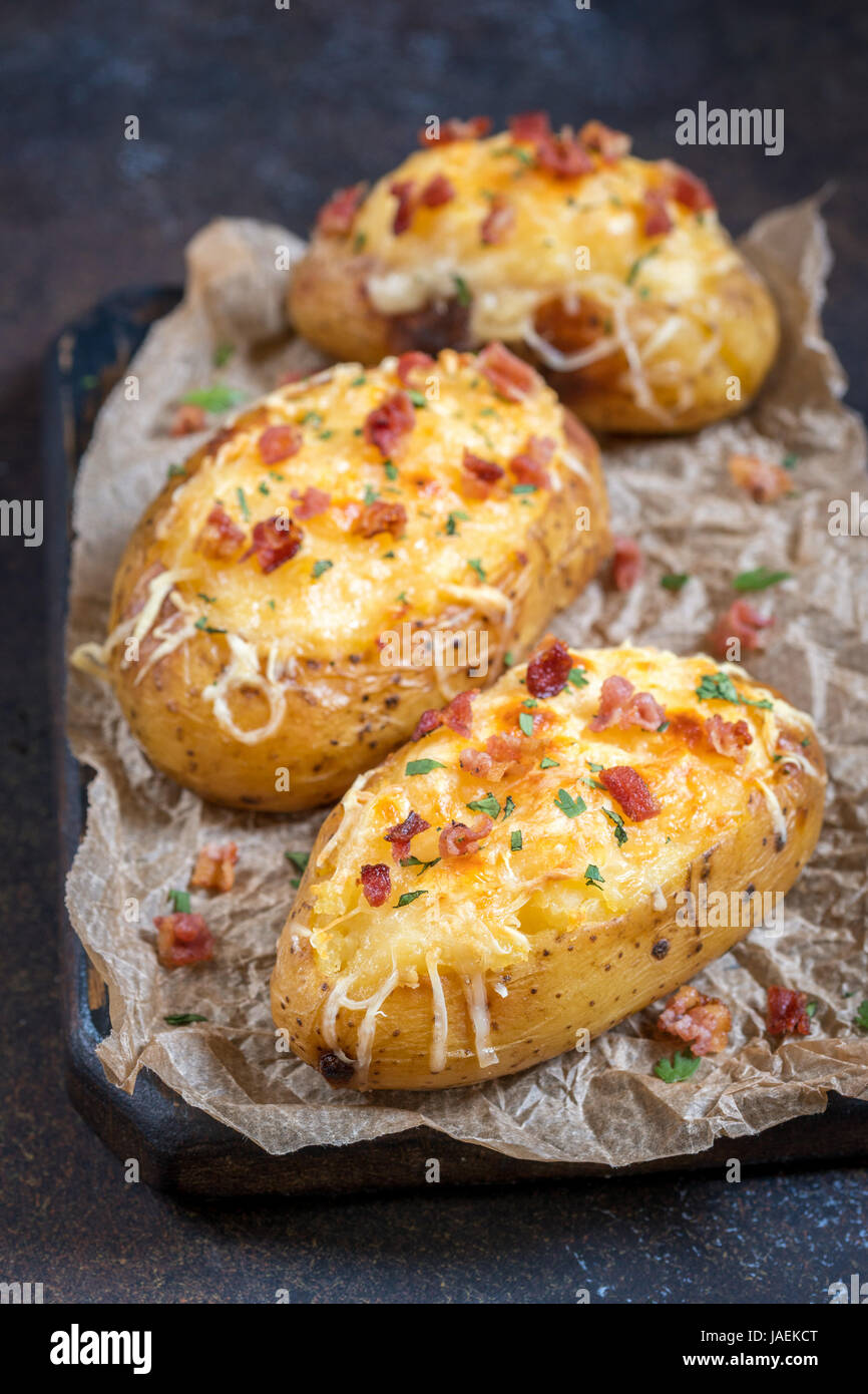 Horneado de patatas rellenas con queso y bacon. Foto de stock