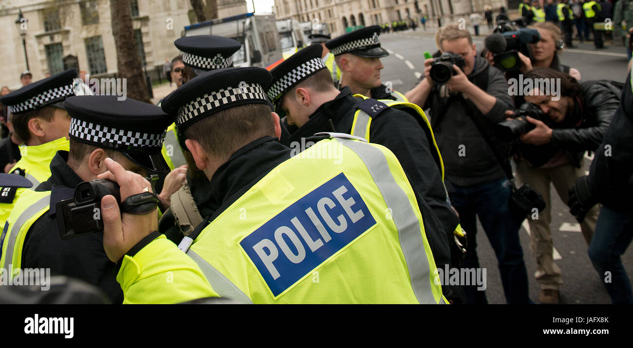 Los agentes de policía luchan con un manifestante en el rally EDL / Gran Bretaña Primero con la demo de contador del movimiento Unite Contra el fascismo en el centro de Londres. Foto de stock