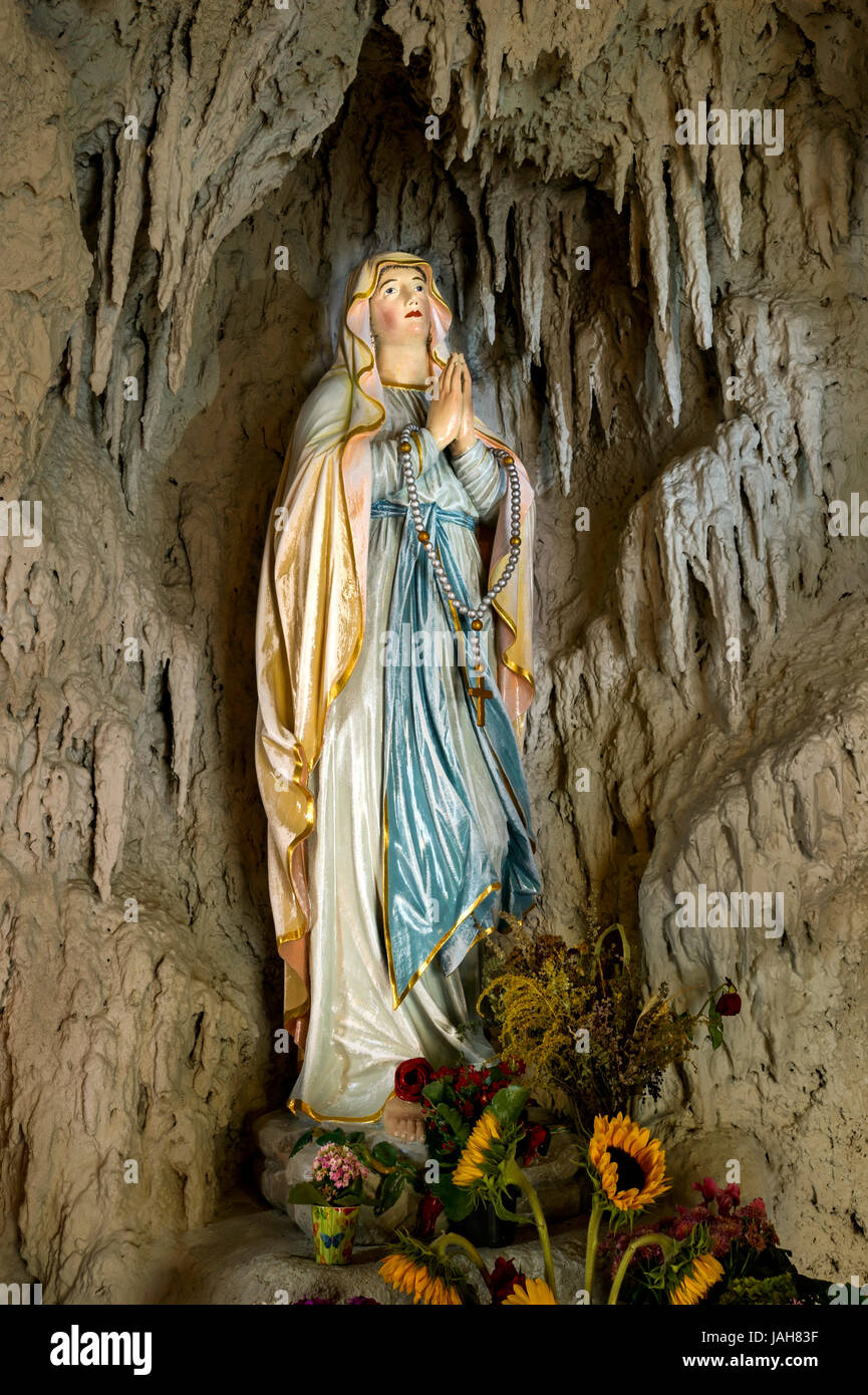 Gruta de Lourdes con una estatua de la Virgen María, la reconstrucción de  la gruta de Massabielle, cerca de Lourdes, la iglesia parroquial de St  Fotografía de stock - Alamy