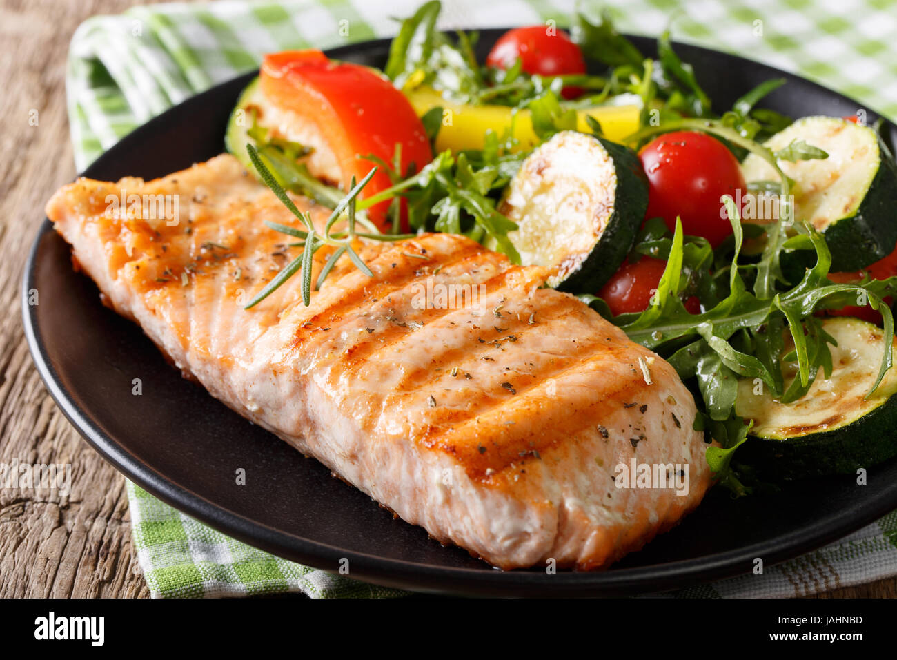 Delicioso filete de salmón a la plancha y ensalada de verduras con rúcula  cerca en una placa horizontal Fotografía de stock - Alamy