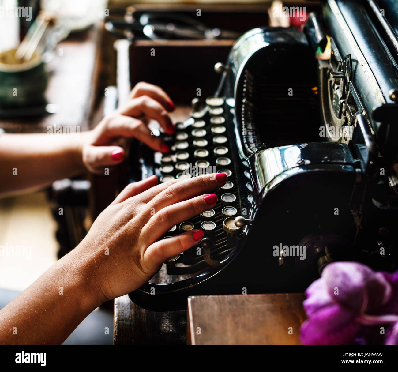 Manos de persona tecleando en maquina de escribir vintage en mesa de  madera. Stock Photo