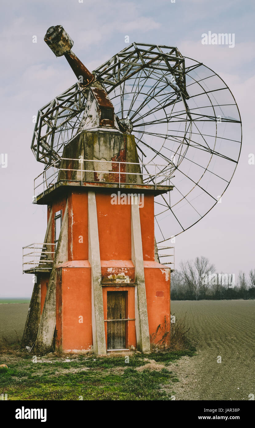 Retro futuro: rotas y abandonadas radio telescopio en la llanura del valle del Po, cerca de Bolonia, Italia. Foto de stock