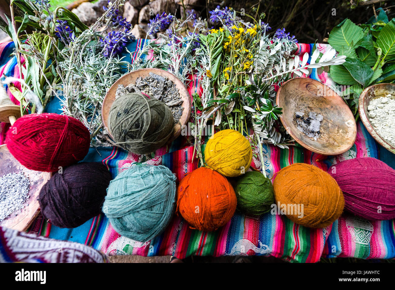 Amaru personas utilizando tintes naturales de lana de oveja color para hacer bolas de hilo. Foto de stock