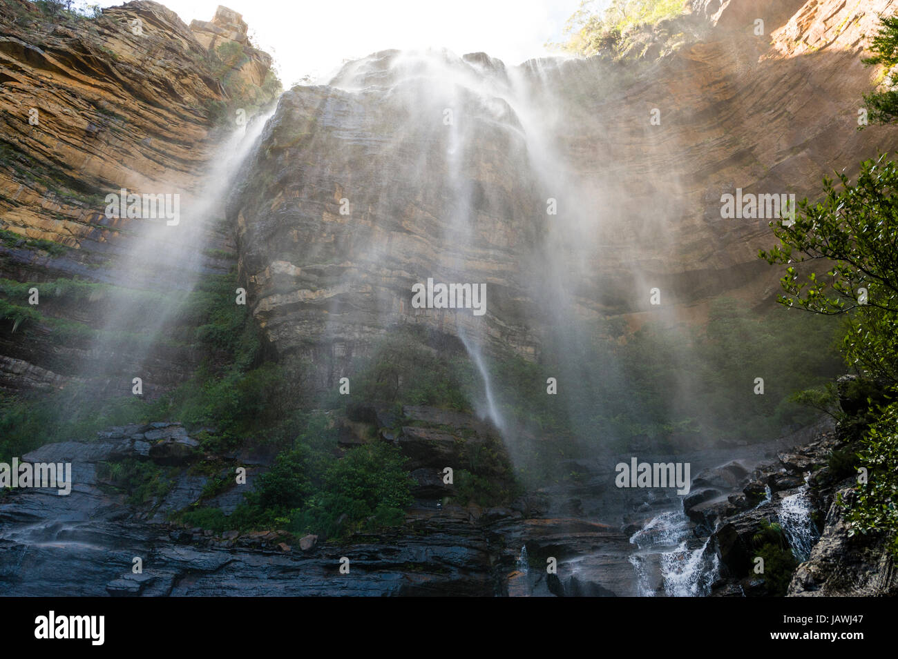 Una cortina de niebla y cascadas de agua de una cascada en un acantilado de piedra arenisca. Foto de stock