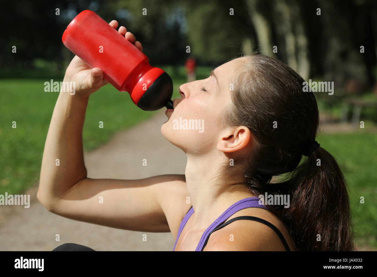 Eine attraktive Sportlerin trinkt Wasser beim deporte oder Laufen Foto de stock