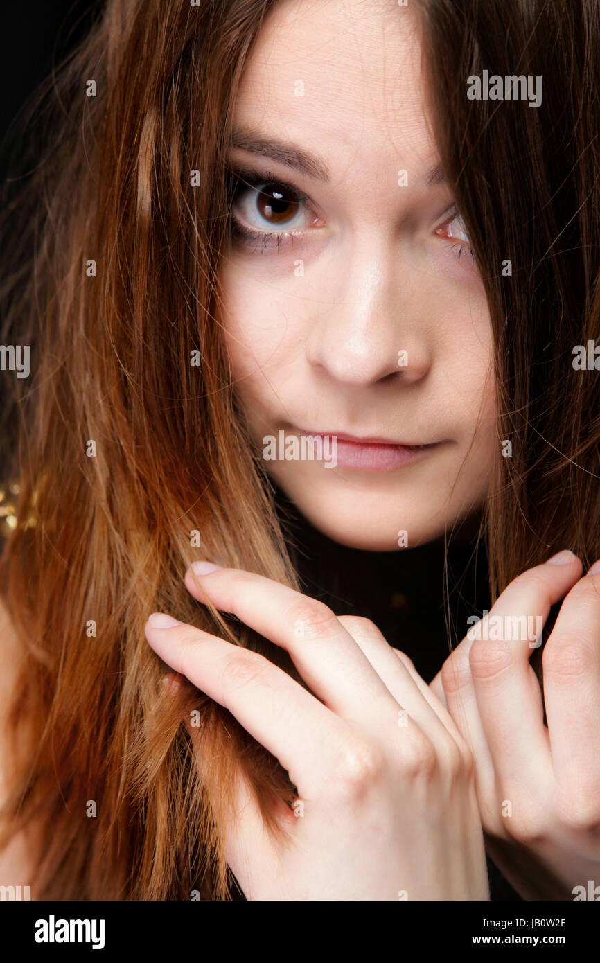 Close-up retrato de una bella mujer cubre el rostro por largos pelos marrones Foto de stock