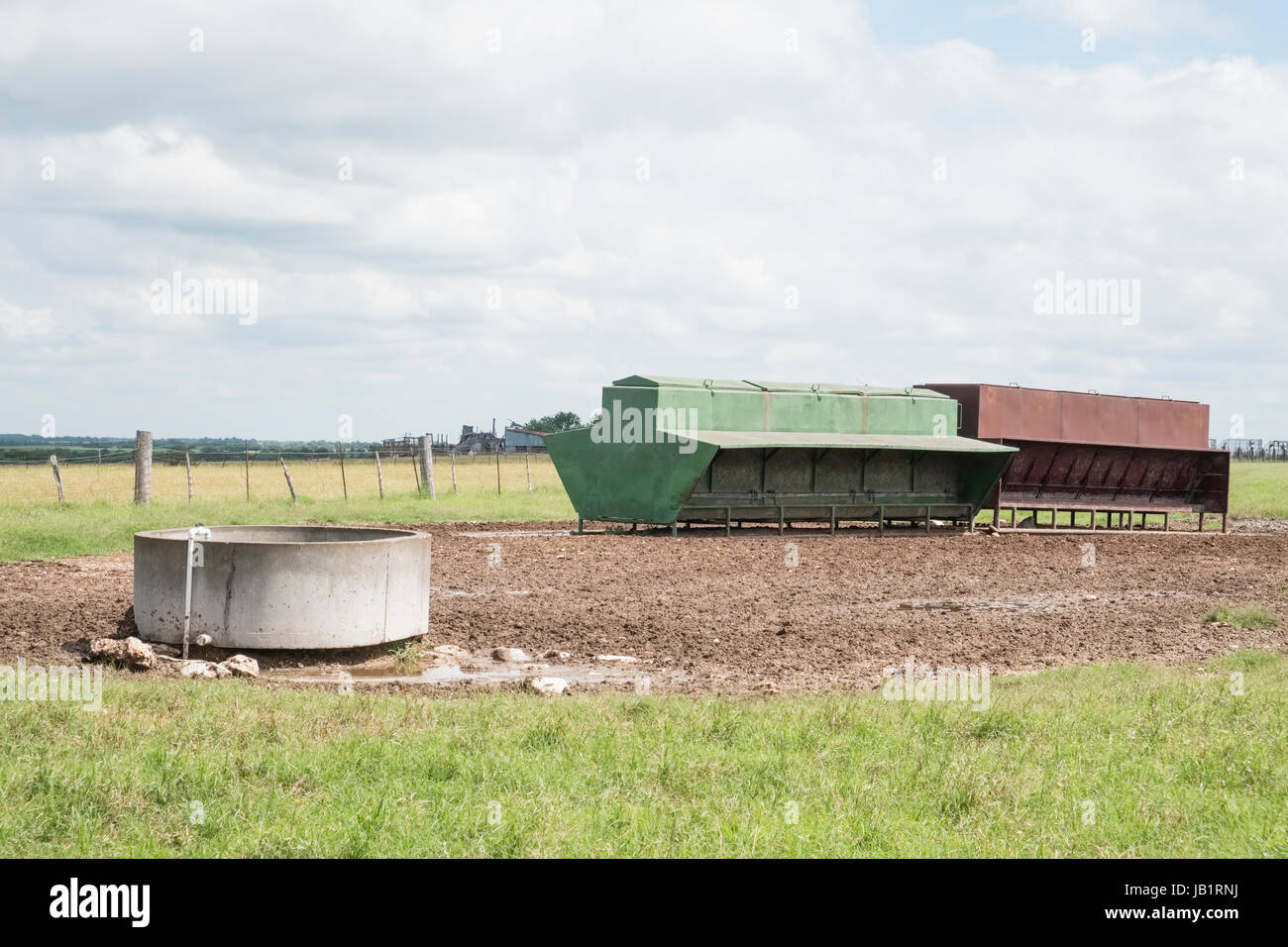 Un pequeño lote de piensos para ganado con comedero de agua en Texas Prairie para barro Foto de stock