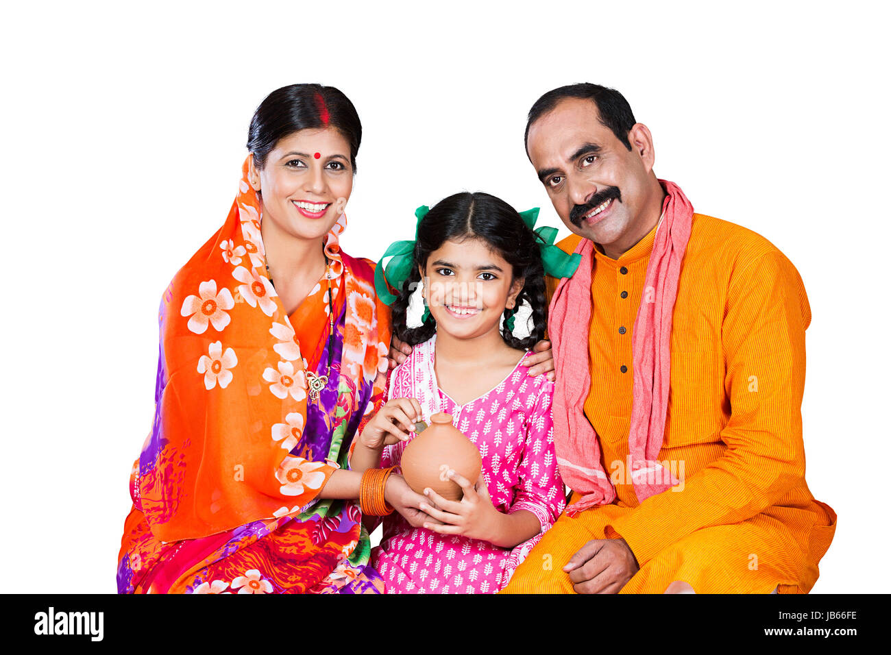 Feliz familia rural indio- Padres y Kid hija sentados juntos y poniendo Coin Hucha ahorrar dinero Foto de stock