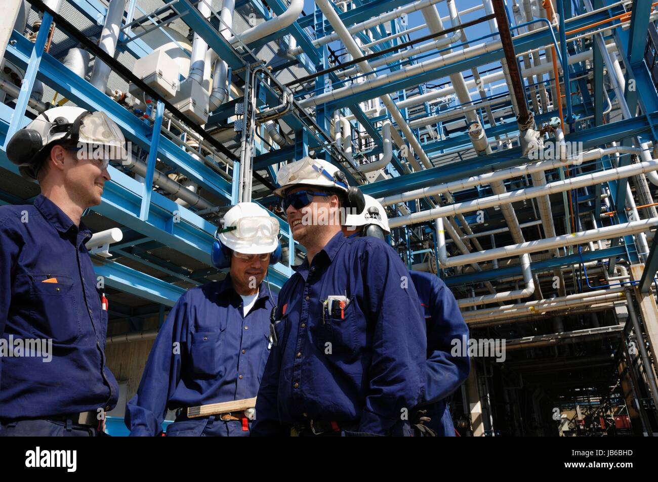 Modelo liberado. Los trabajadores industriales en la refinería de petróleo y gas. Foto de stock
