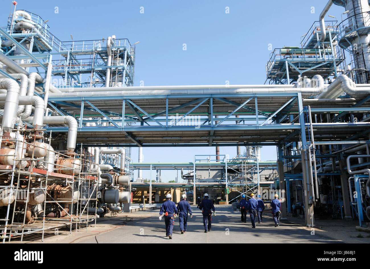 Los trabajadores industriales en la refinería de petróleo y gas. Foto de stock