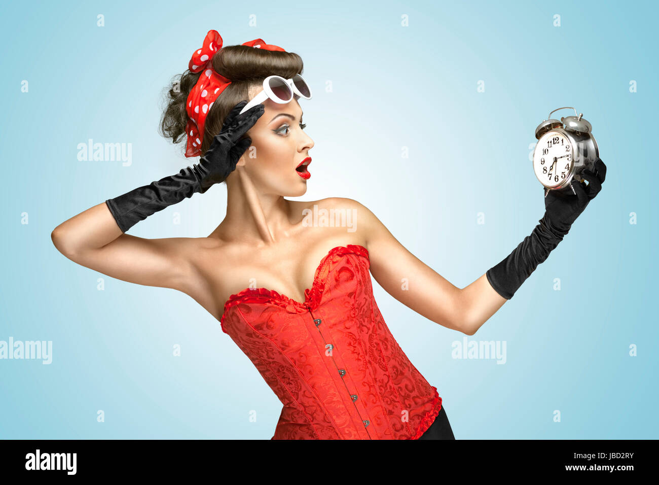 El marco conceptual de la foto de una chica pin-up en la ropa interior y  guantes glamour viendo en el reloj Fotografía de stock - Alamy