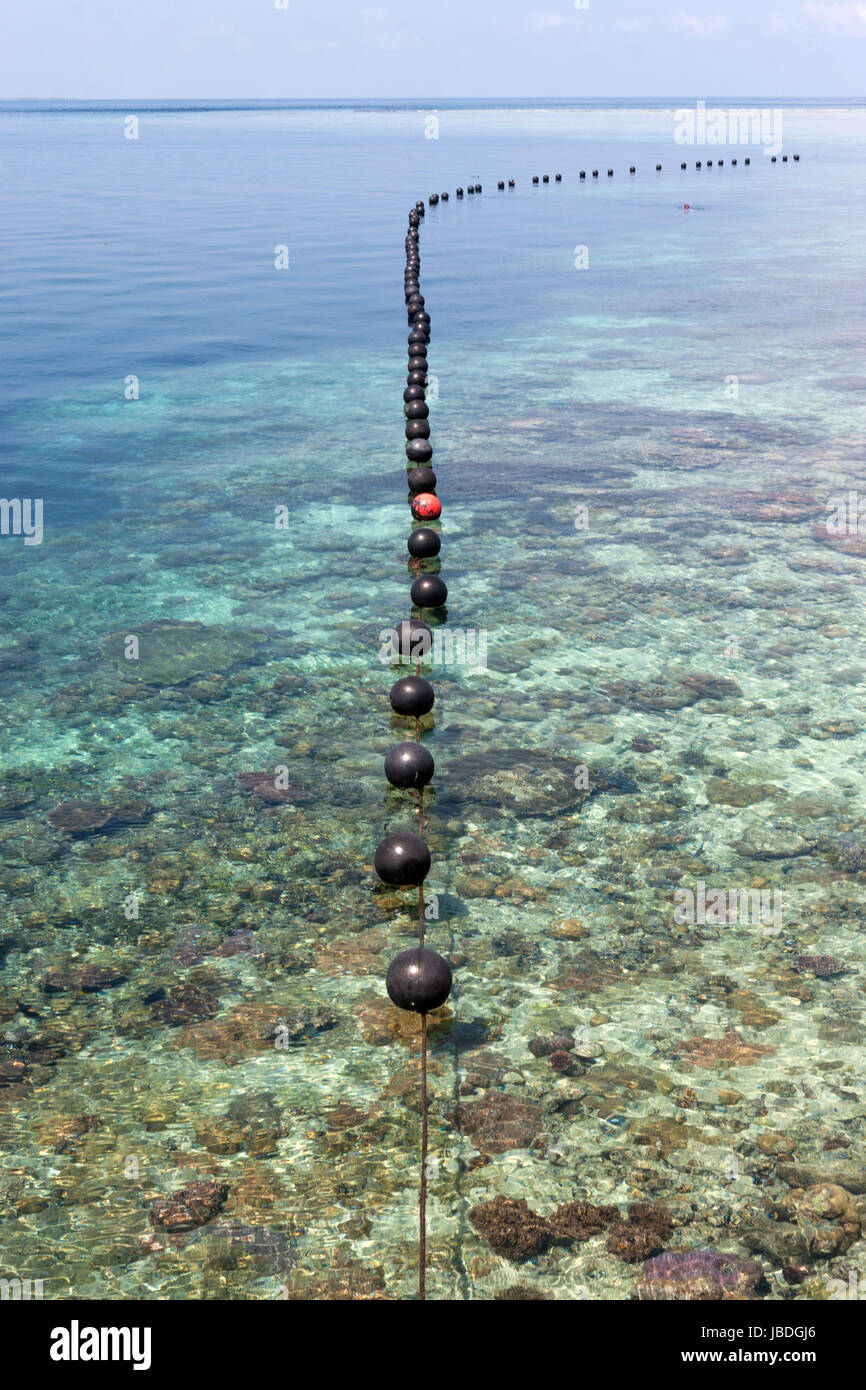 Sipadan, Borneo, Malasia - una cadena de poco boyas flotando sobre un arrecife de coral. Foto de stock